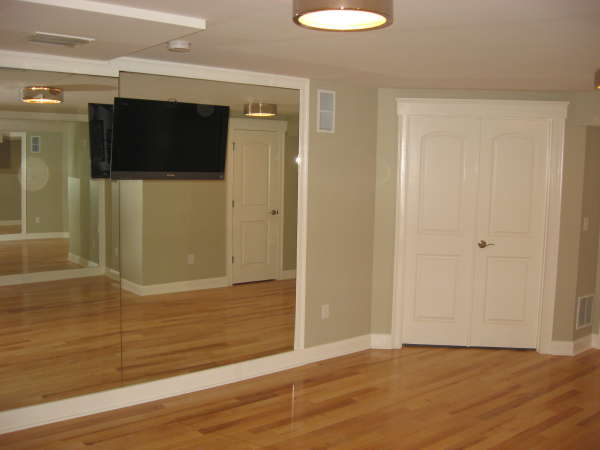 Basement exercise room with mirrors and tv